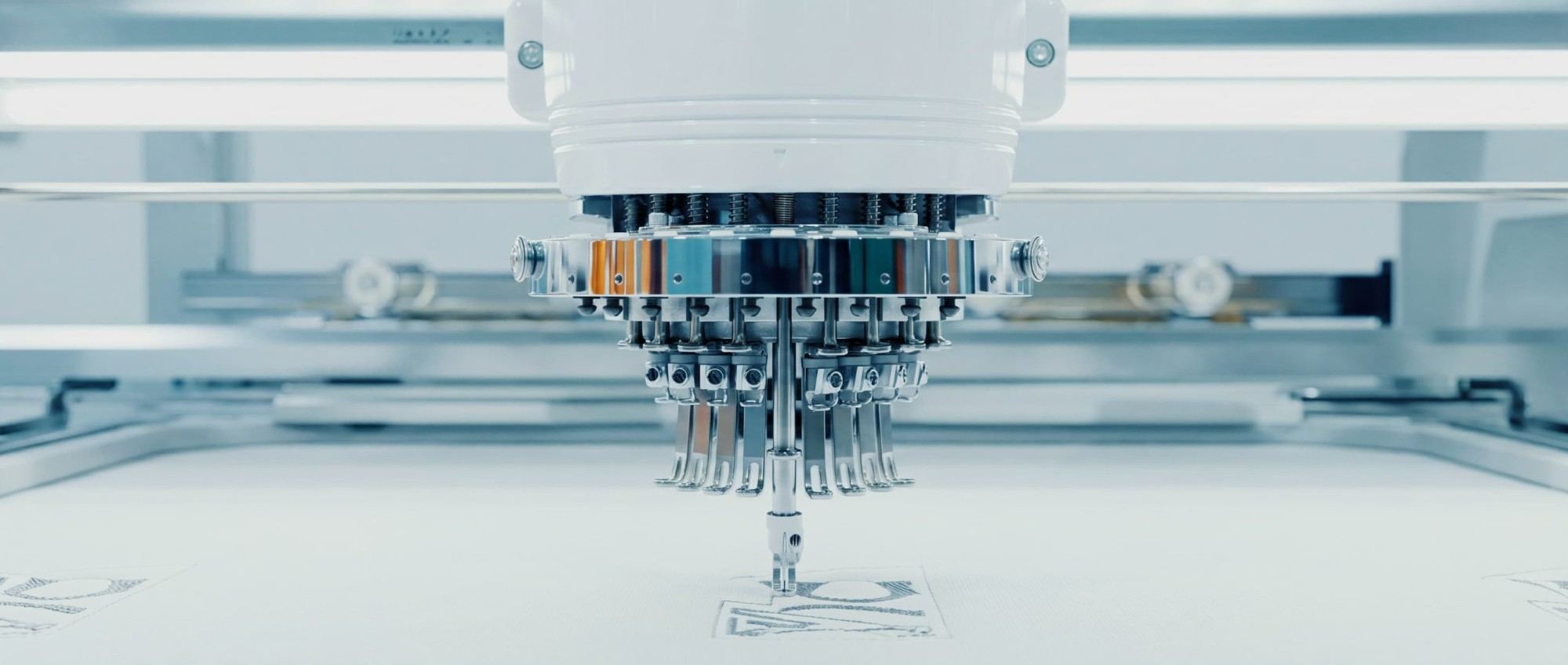 Embroidery head stitching a motif into panel fabric